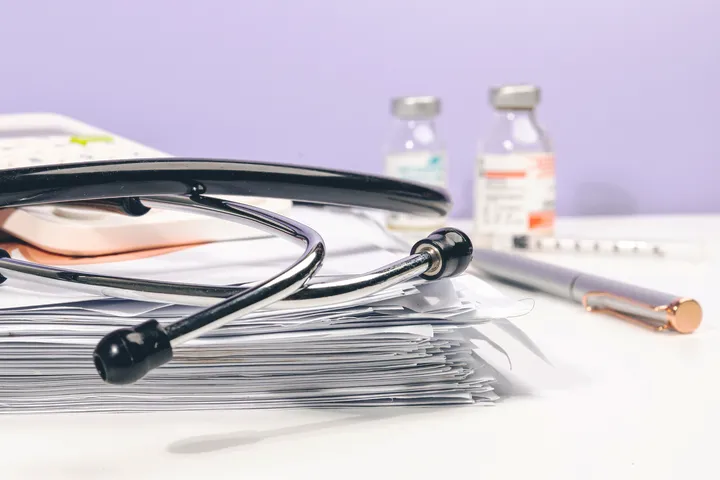 Stethoscope on medical files with vials and pen, medical malpractice in NYC