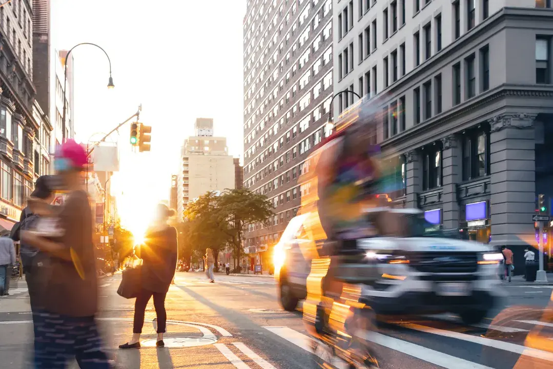 Busy New York City street with cars, cyclists, and pedestrians at sunset, representing the New York Personal Injury Practice Areas handled by Burdzy & Associates.