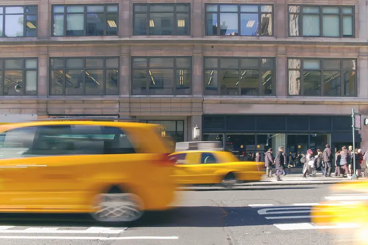 Yellow cabs moving along a Manhattan street, rideshare and taxi accidents in NYC